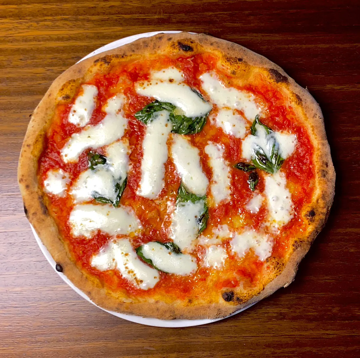 Pizza Margherita de Impasto sobre una mesa de madera