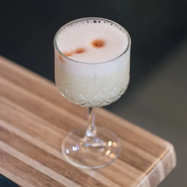 Pisco sour con espuma y gotas de amargo de angostura